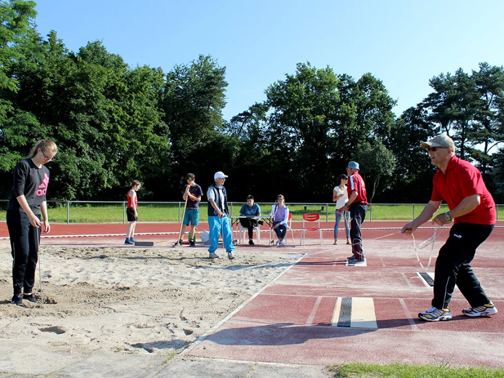 Betreuung an der Weitsprunganlage mit Wartenden.